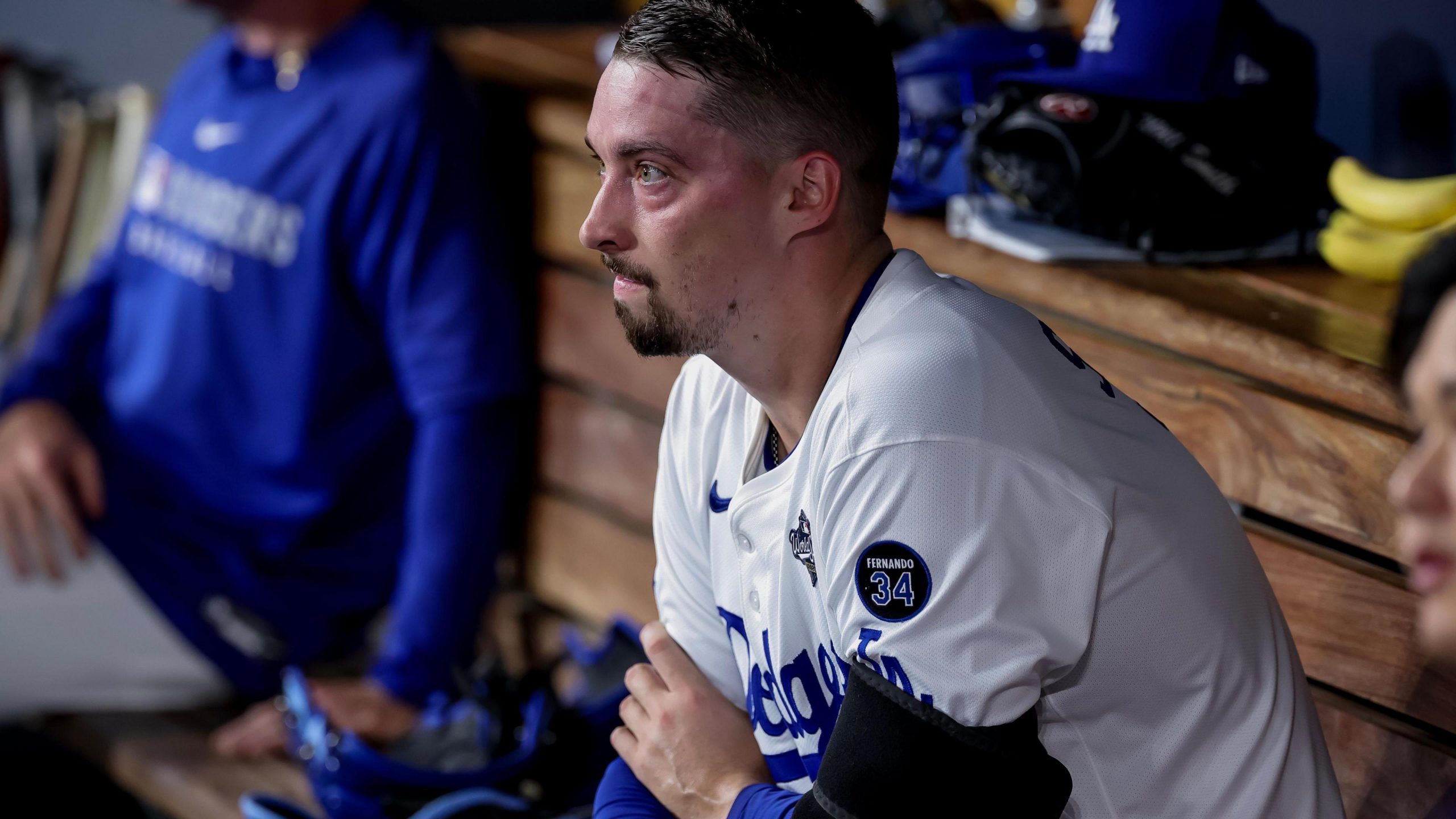 Les Angeles Dodgers pitcher Blake Snell sits, bare-headed, in the dugout